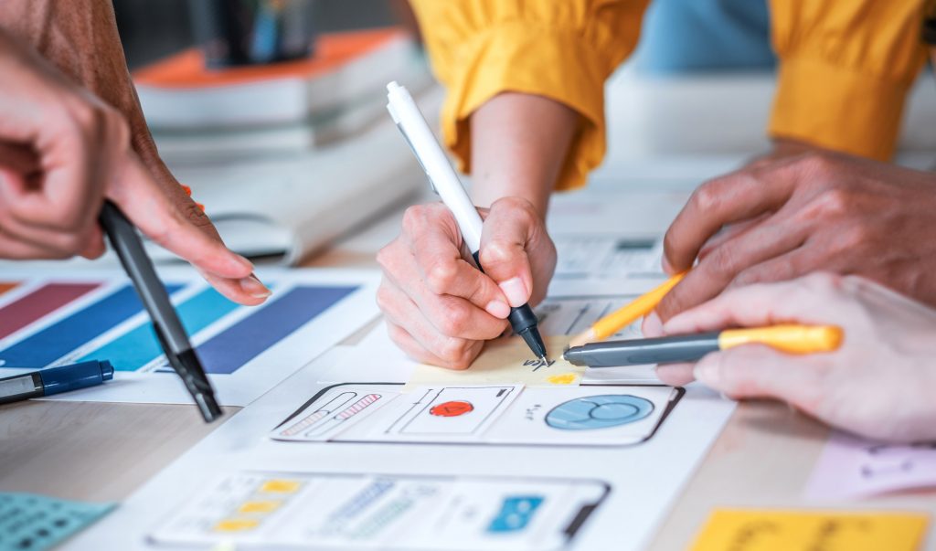 a girl preparing a mockup of a mobile app on a sheet of paper